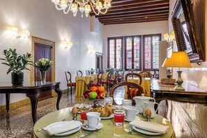 A dining area with a table set for breakfast, including fruits, pastries, and beverages. - Hotel Casa Verardo Residenza d'Epoca (Venice)