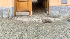 A building entrance with a wooden door, cobblestone pavement, and a sign indicating the address 393. - Residence Casa Italia  (Prague)