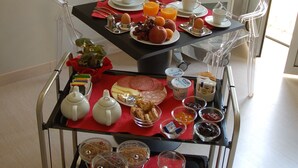 A breakfast trolley with a variety of food items and a potted plant. - Best Vatican B&B (Rome)
