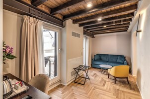 A room with a wooden ceiling, a sofa, a yellow chair, a small table, and a radiator.