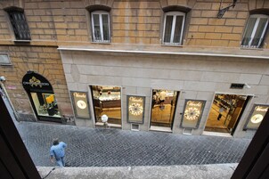 A street view with a building featuring storefronts with illuminated signs.