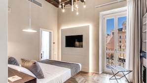 A modern bedroom with a bed, bedside table, and a TV mounted on the wall.