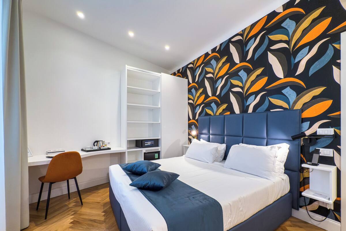 Un dormitorio moderno con una cama, un escritorio y un armario.