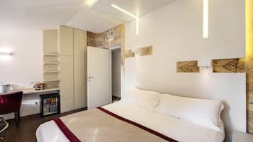Una habitación de hotel moderna con una cama grande, un escritorio y un minibar.