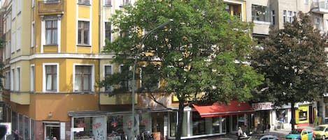 A multi-story building with a yellow facade and a corner turret.