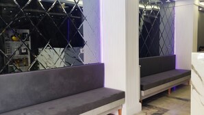 A modern interior with a marble reception desk, a staircase with a geometric patterned wall, and a clock on the wall. - Star Hotel Istanbul - Special Class (Istanbul)