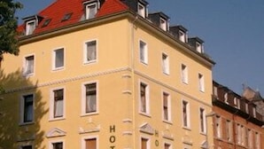 A yellow building with the word "HOTEL" on the side, multiple windows, and a red roof. - Hotel Classic Inn (Heidelberg)