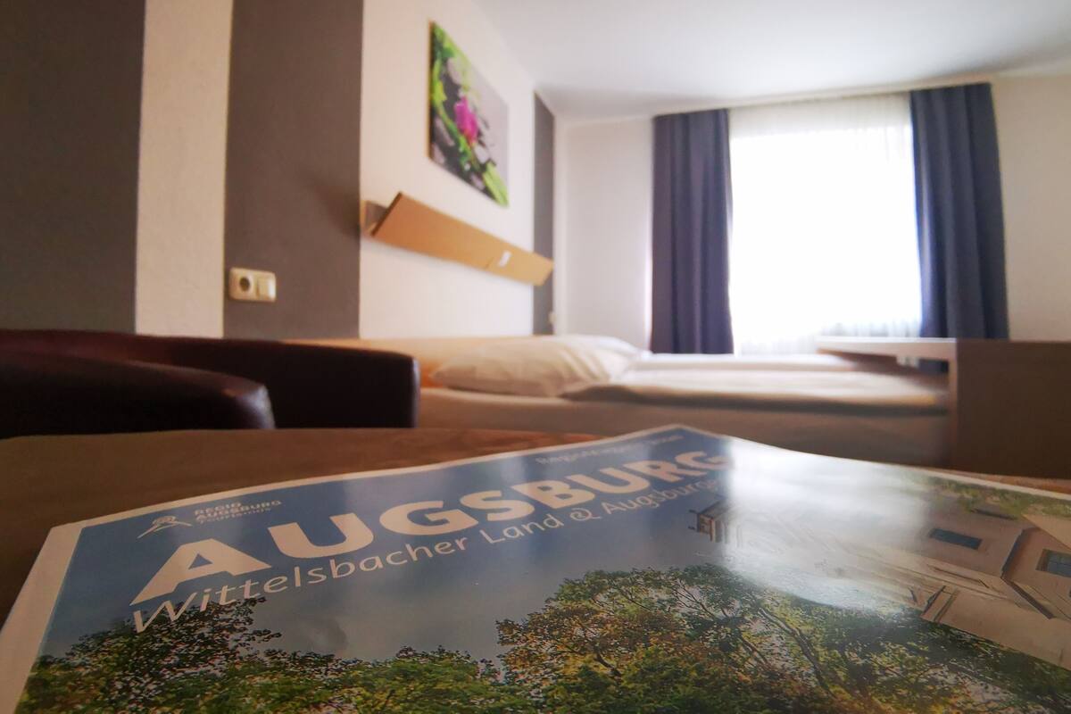 Une chambre d’hôtel avec un lit, un bureau et un magazine sur la table.