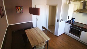 A compact kitchen with a dining area, a hanging lamp, and a stove. - Hotel Jakoberhof (Augsburg)
