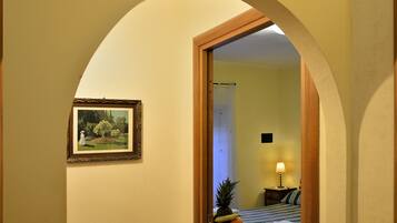 Una camera d'albergo con un letto, un comodino, una lampada e un quadro appeso al muro.