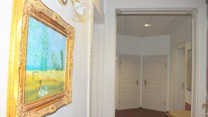 A hallway with a framed painting on the wall, double doors, and a carpeted floor. - Hotel Novalis (Berlin)