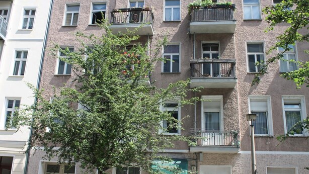 A multi-story apartment building with balconies, windows, and a tree in front. - Hotel Novalis (Berlin)