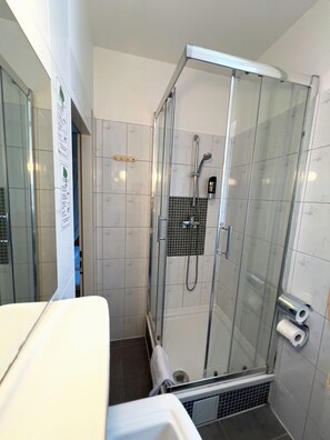Habitación estándar doble | Baño | Ducha, secador de pelo y toallas