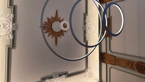 A ceiling with a decorative sun motif, ornate moldings, and a circular light fixture. - Hotel Seifert Berlin am Kurfürstendamm (Berlin)