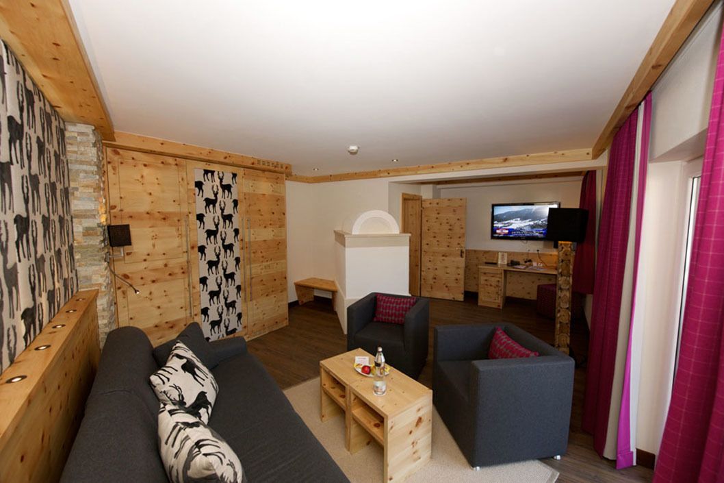 Een moderne woonkamer met een houten accentmuur, een bank, een salontafel en een televisie op de achtergrond.