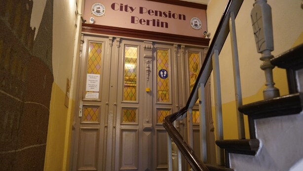 A staircase leading to a door labeled "City Pension Berlin" with a sign indicating a wheelchair-accessible entrance. - City Pension Berlin (Berlin)