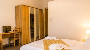 Une chambre d’hôtel comprenant un lit, un bureau, une chaise et une armoire.