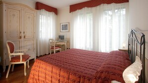 A bedroom with a large bed, a desk, a chair, and a wardrobe. - Ca' San Rocco (Venice)