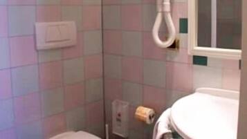 Ein Badezimmer mit Toilette, Waschbecken und Spiegel.