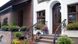 A building with a brick facade, a wooden door, and steps leading to the entrance. - Oliwa Park Residence (Gdansk)