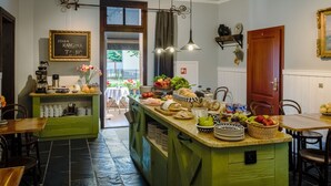 A kitchen with a central island, a dining area with chairs, and a view of the outdoors. - Oliwa Park Residence (Gdansk)