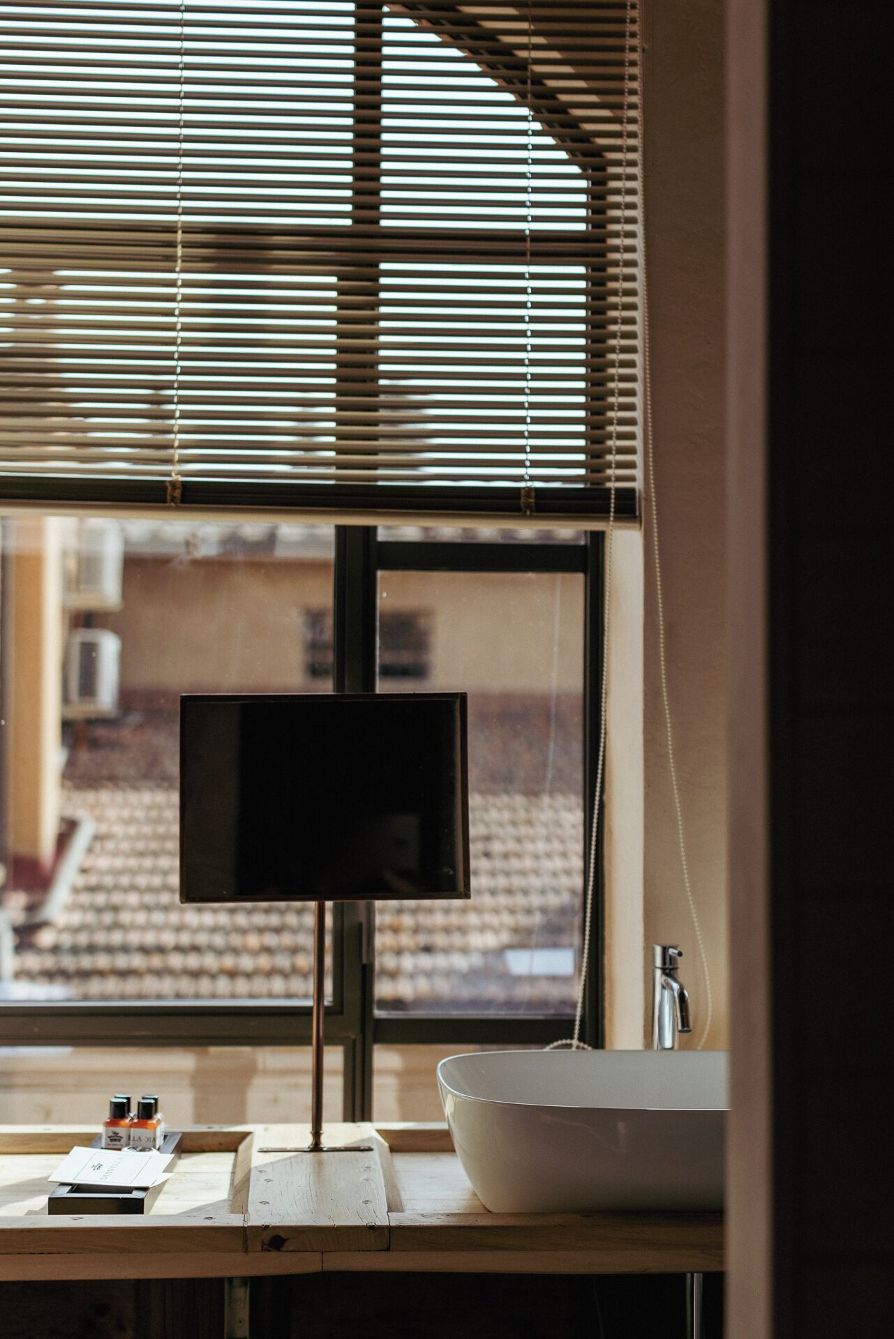 Une salle de bain avec une grande fenêtre, un lavabo et un miroir.