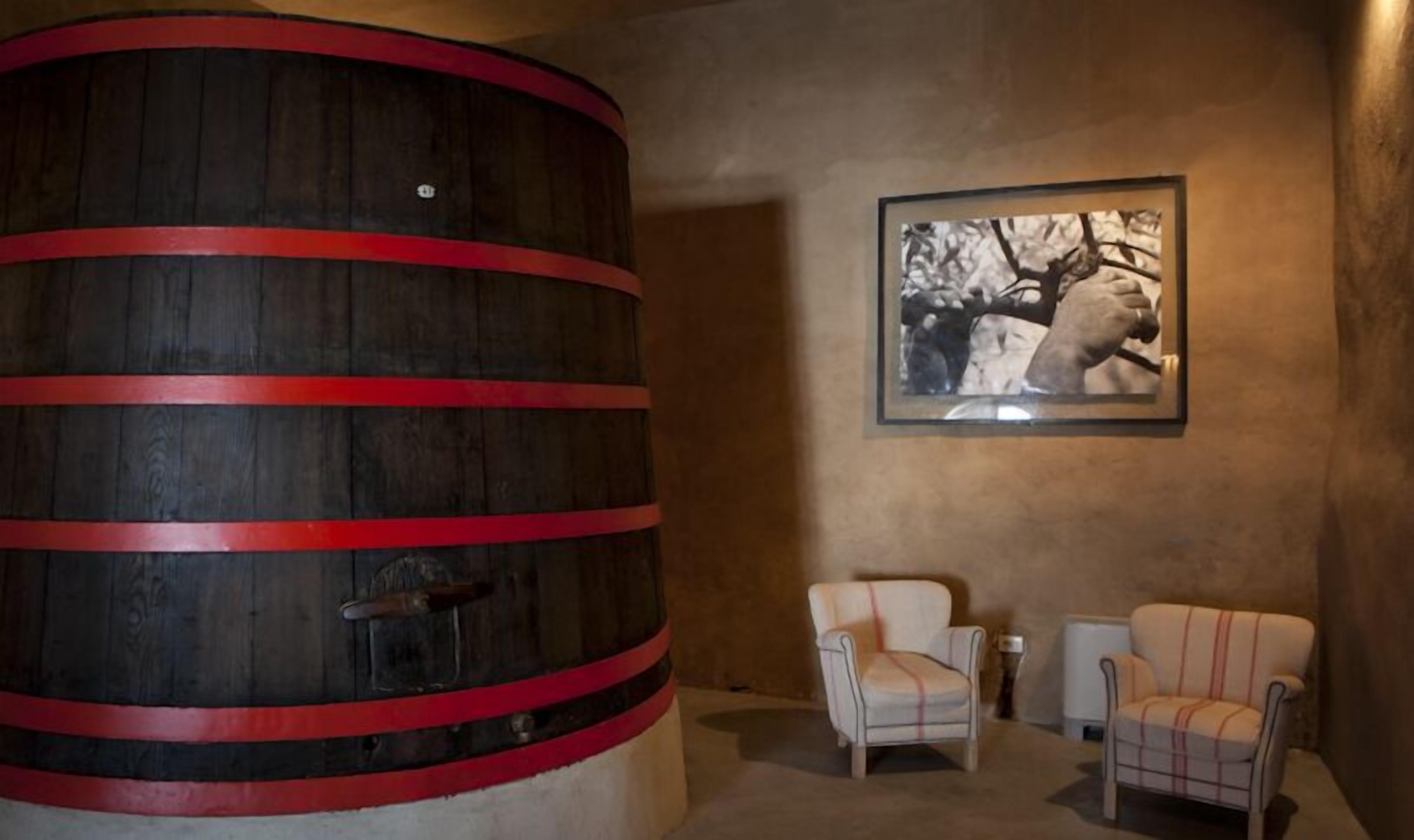 Une pièce comprenant une grande cuve en bois, deux fauteuils et un tableau encadré accroché au mur.