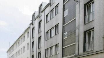 Ein mehrstöckiges Hotel mit schlichter Fassade, mit einem Schild, auf dem "HOTEL" steht, und einem gut erkennbaren Eingang.