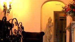 A lobby with a statue, a candelabra, and a sofa.