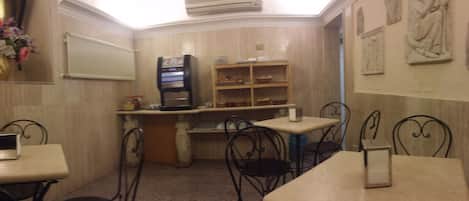 A small, cozy restaurant with a counter, a refrigerator, and a few tables and chairs.