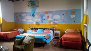 A room with two beds, a chair, and a wall mural. - Il Pioppo e la Fonte (Castello d'Agogna)