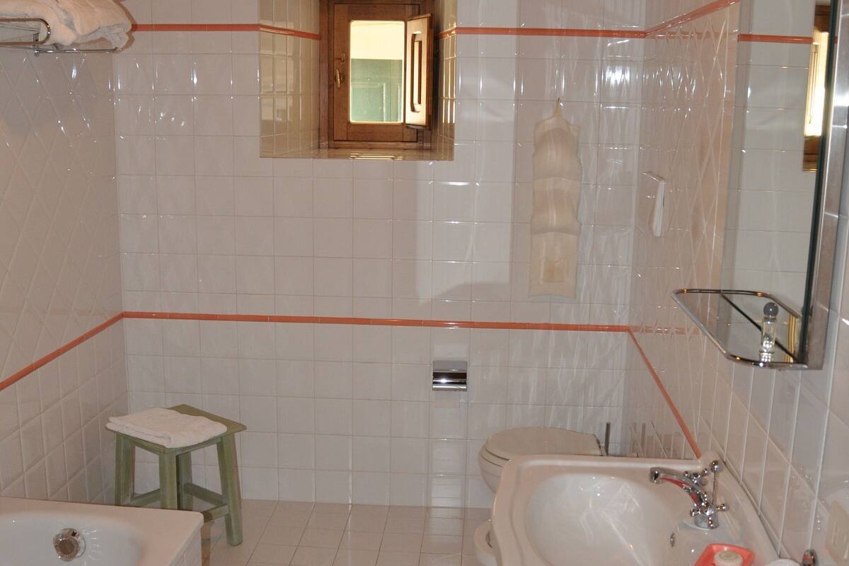 Een badkamer met een bad, wastafel en toilet.