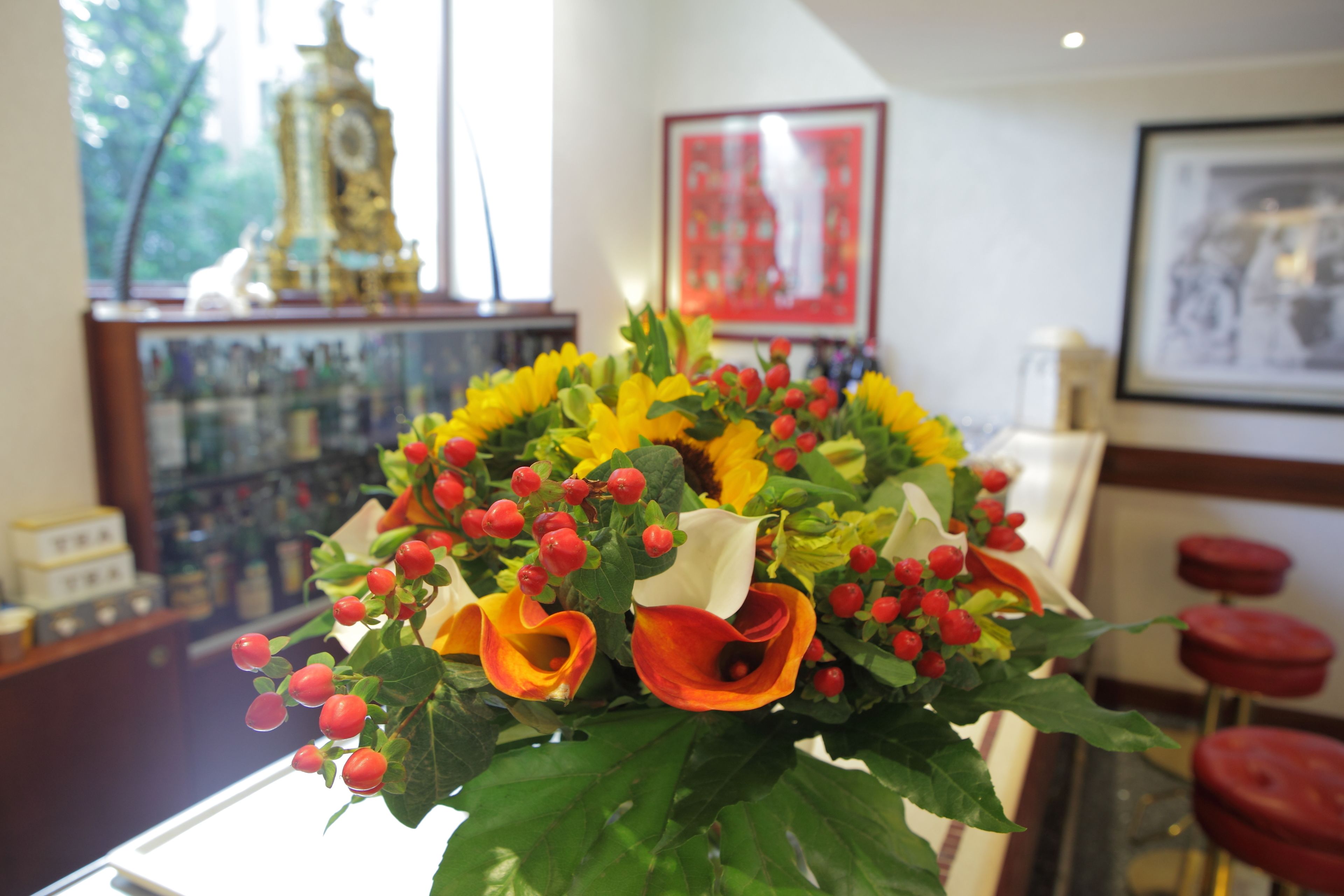 A room with a table displaying a floral arrangement.