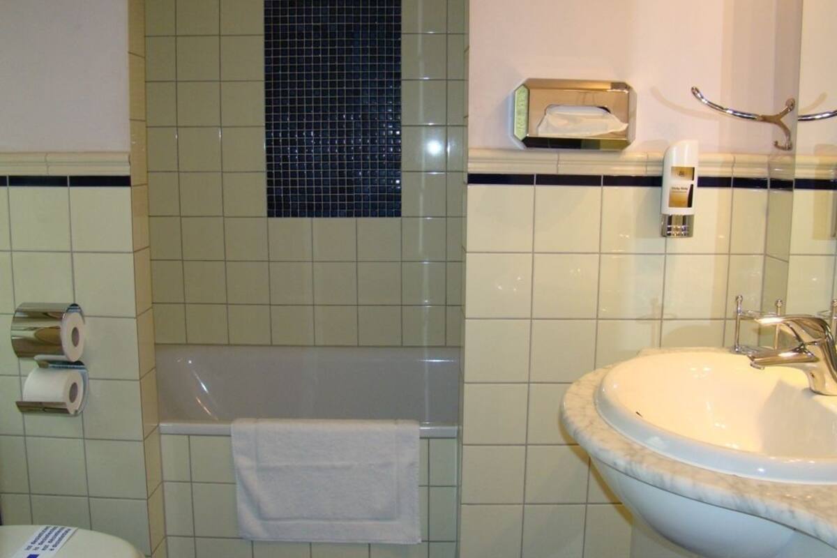 Une salle de bain avec une baignoire, un lavabo et un miroir.