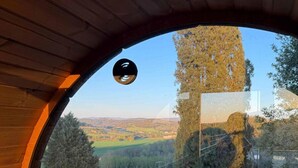 Un interior de madera con techo curvo y vista a un paisaje a través de una ventana.