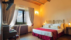 Un dormitorio con cama de madera, un escritorio con silla, una ventana con cortinas y una lámpara fijada a la pared.