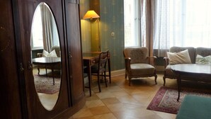A room with a wooden wardrobe, a desk, a chair, a sofa, and a lamp. - Hotel-Pension Funk (Berlin)