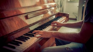 Eine Person spielt ein Hupfeld-Klavier.
