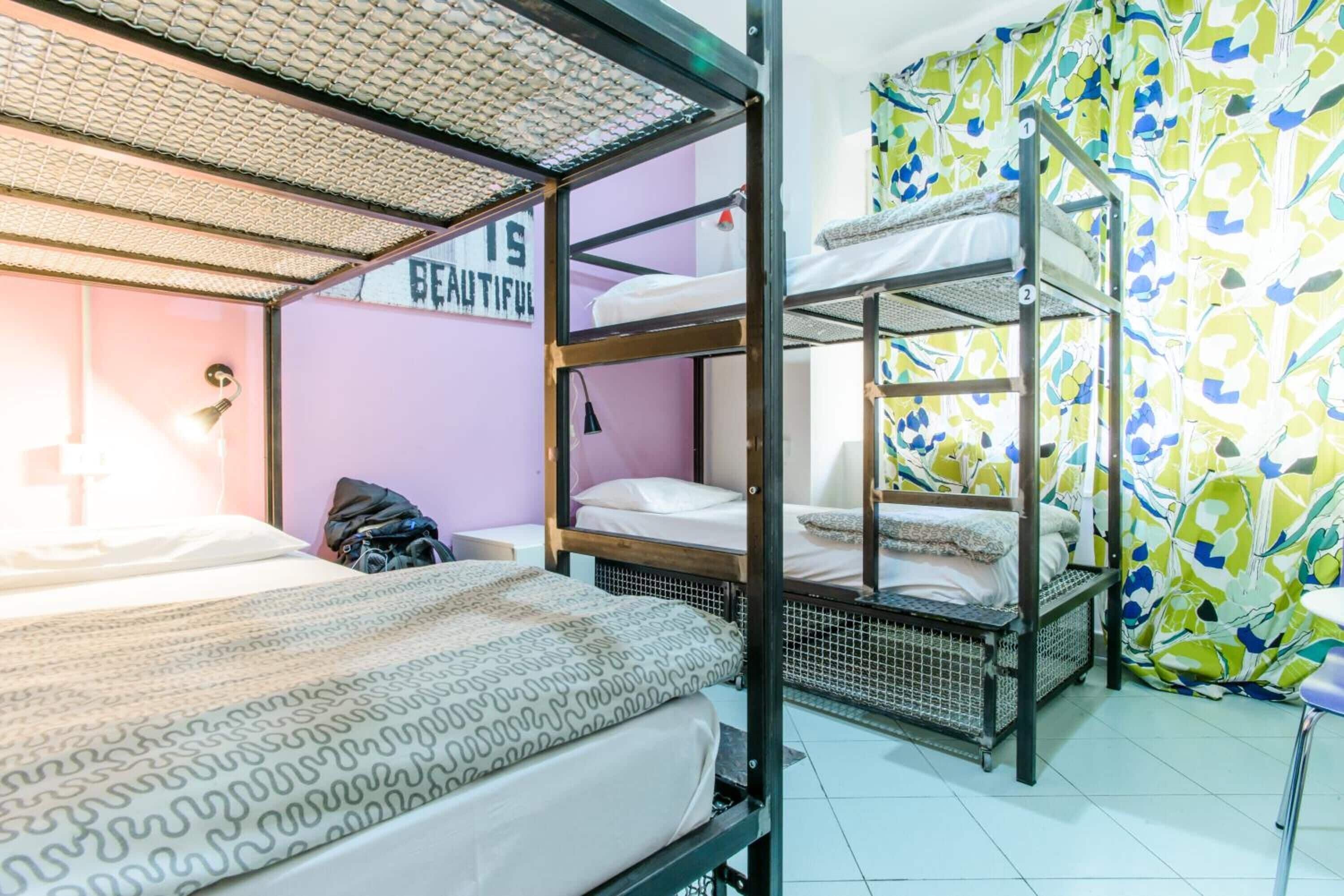 A bunk bed room with a 'BEAUTIFUL' sign, a patterned bedspread, and a colorful curtain.