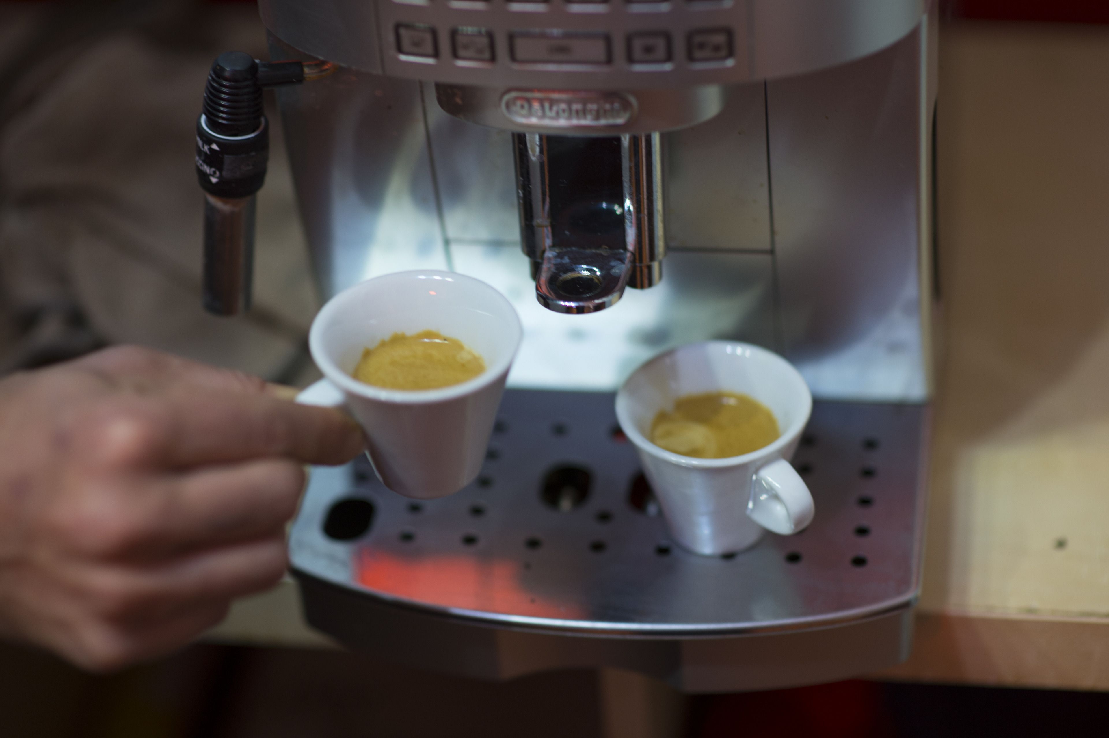 A coffee machine dispensing coffee into two cups.