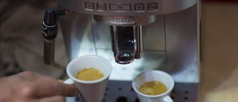 A coffee machine dispensing coffee into two cups.