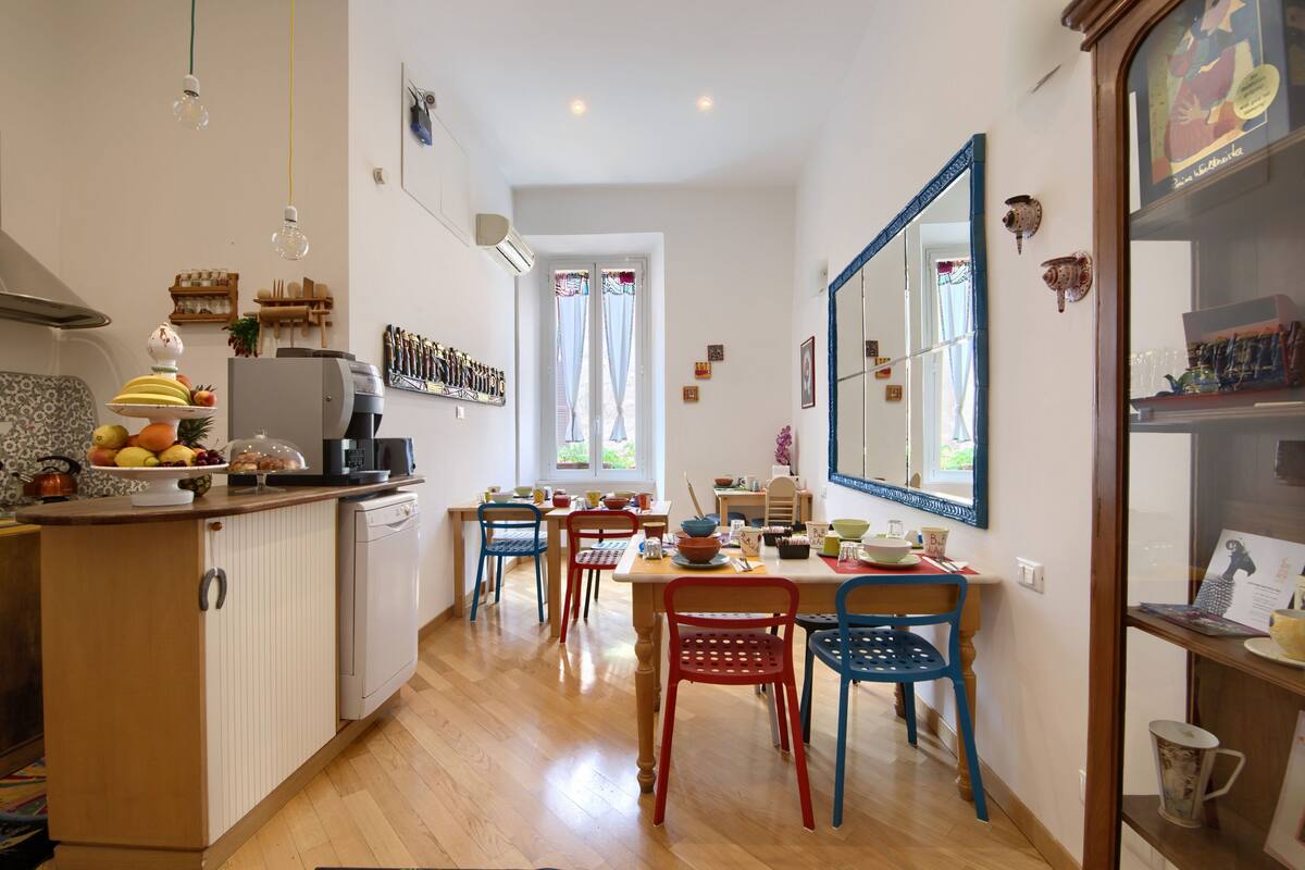A kitchen with wooden cabinets, a dining table with chairs, and a large mirror on the wall.