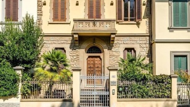 A two-story building with a central entrance, stone facade, and shutters on windows. - Sangaggio House B&B (Florence)