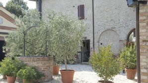 A courtyard with potted plants and a stone floor. - Il Pettirosso di Siena (Siena)