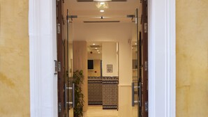 A hotel entrance with a tiled floor, a reception desk, and a patterned wall. - U-Sense Sevilla Centro (Seville)