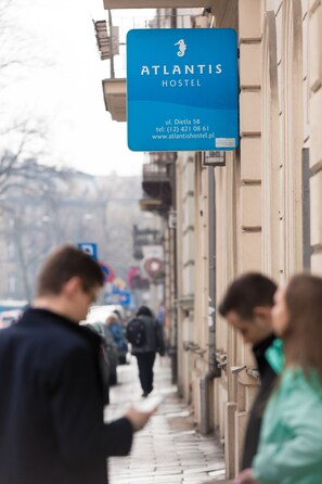 A sign for Atlantis Hostel with contact details and a website URL. - Hostel Atlantis (Kraków)