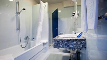 Uma casa de banho moderna com banheira, chuveiro e lavatório.