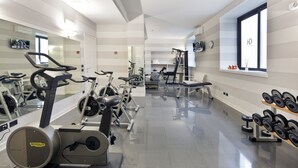 Une salle de sport moderne équipée de divers appareils d’exercice, notamment des tapis de course, des vélos d’appartement et des poids libres.