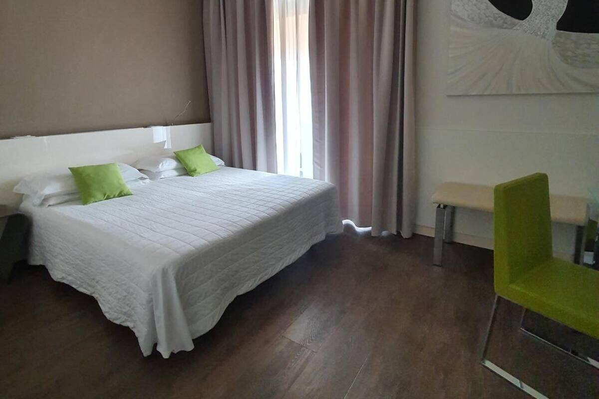 Une chambre d’hôtel avec un lit, un banc et une chaise.