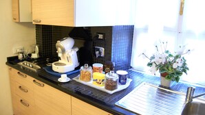 Une cuisine équipée d’une machine à café, de pots d’épices et d’une plante en pot.